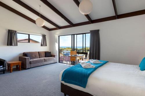 a bedroom with a large bed and a living room at Unit 5 Kaiteri Apartments and Holiday Homes in Kaiteriteri