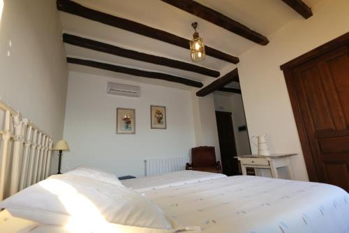 a bedroom with a white bed and a wooden ceiling at Casa Rural Rincón de la Fuente in Buenaventura