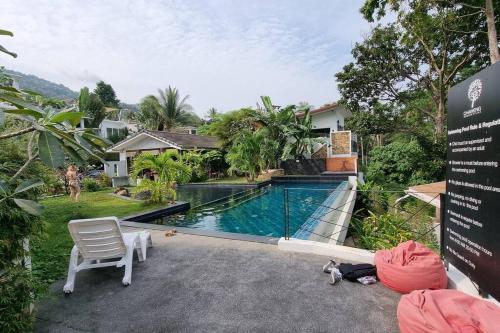 uma piscina com uma cadeira e uma casa em Chaweng Beautiful Studio. em Koh Samui