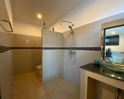 a bathroom with a glass shower and a sink at Chaweng Beautiful Studio. in Koh Samui 