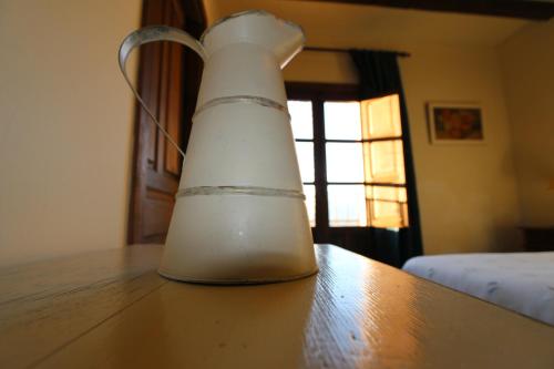 a white vase sitting on top of a wooden table at Casa Rural Rincón de la Fuente in Buenaventura