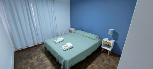 un pequeño dormitorio azul con cama y mesita de noche en Mingo's Appartment en Godoy Cruz