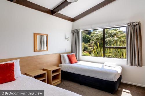 a bedroom with two beds and a window at Unit 7 Kaiteri Apartments and Holiday Homes in Kaiteriteri