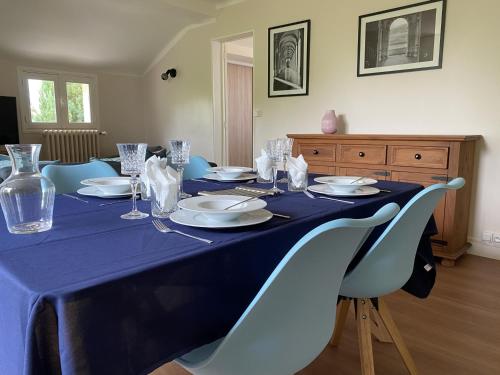 une table bleue avec des assiettes et des verres dans l'établissement Charmant T3 avec jardin privé, proche des Thermes, bien équipé, parking inclus - FR-1-541-97, à La Roche-Posay