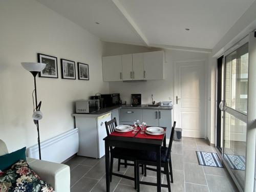 une cuisine et une salle à manger avec une table et des chaises dans l'établissement Studio lumineux avec jardin privé et terrasse en plein centre de La Roche-Posay - FR-1-541-96, à La Roche-Posay