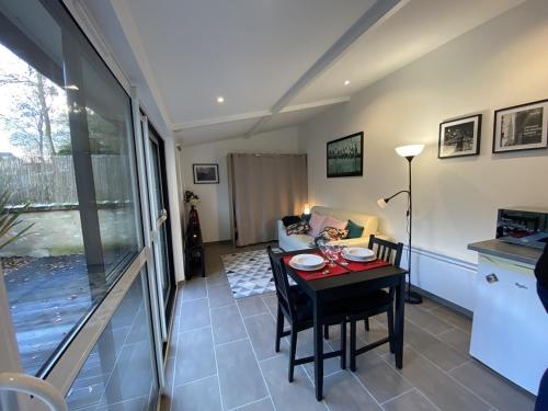 un salon avec une table et un canapé dans l'établissement Studio lumineux avec jardin privé et terrasse en plein centre de La Roche-Posay - FR-1-541-96, à La Roche-Posay