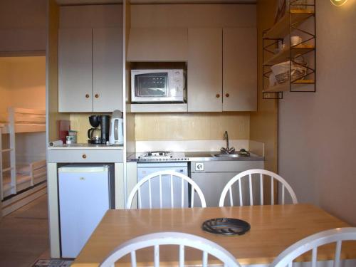 une petite cuisine avec une table et un micro-ondes dans l'établissement Studio Cabine avec Balcon, Fontaine-Romeu - Parking Inclus - FR-1-580-88, à Font-Romeu-Odeillo-Via