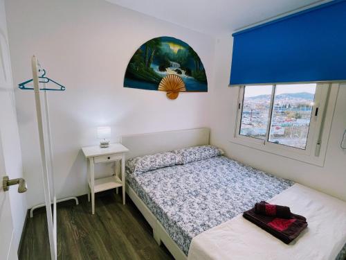 a small bedroom with a bed and a window at Magnifico Apartamento Barca 4 in Sant Adria de Besos