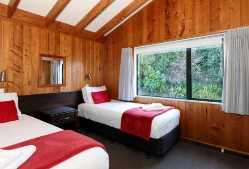 a bedroom with two beds and a window in it at Unit 10 Kaiteri Apartments and Holiday Homes in Kaiteriteri
