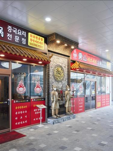 a store with a statue in front of a building at Golden Tulip Incheon Airport Hotel in Incheon