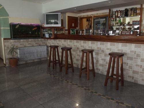 a row of stools at a bar in a restaurant at Hotel Teomar in Villa Gesell