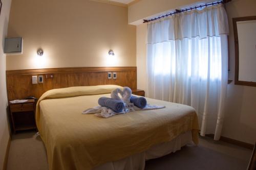 a hotel room with a bed with a stuffed animal on it at Hotel Teomar in Villa Gesell