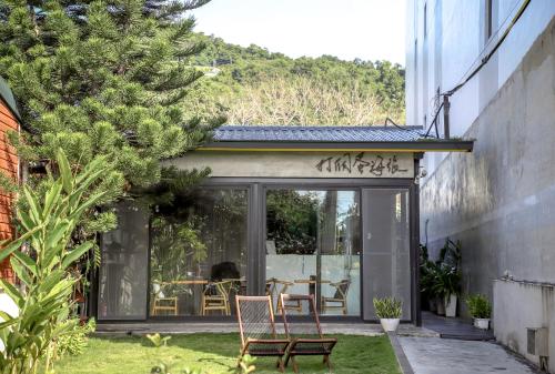 a glass extension of a house with a table and chairs at Dagedan House 金崙海邊民宿 in Taimali