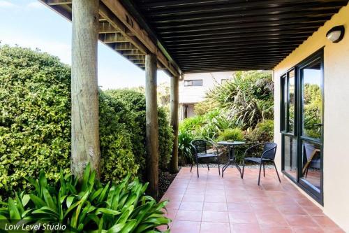 a patio with chairs and a table on a porch at Unit 11 Kaiteri Apartments and Holiday Homes in Kaiteriteri