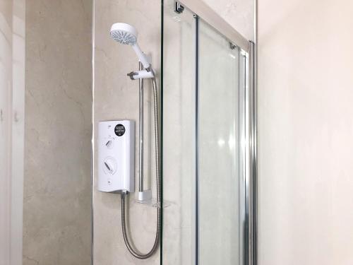 a shower with a shower head in a bathroom at The Larches in Aspatria