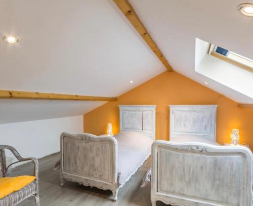 two beds in a room with an attic at Canadian Beach Hut in Bénerville-sur-Mer