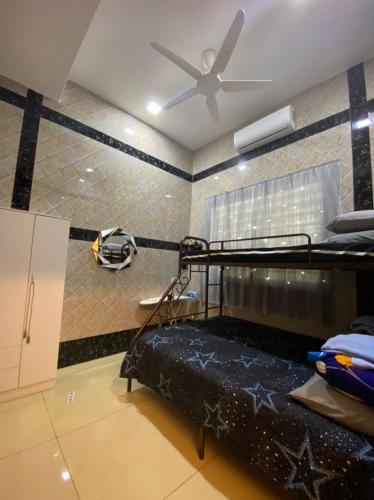 Camera con letto a castello e ventilatore a soffitto. di Homestay Bota Sunrise a Kampung Bota Kiri