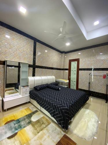ein Schlafzimmer mit einem schwarzen Bett in einem Zimmer in der Unterkunft Homestay Bota Sunrise in Kampung Bota Kiri