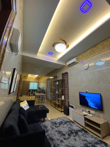 a living room with a couch and a flat screen tv at Homestay Bota Sunrise in Kampung Bota Kiri