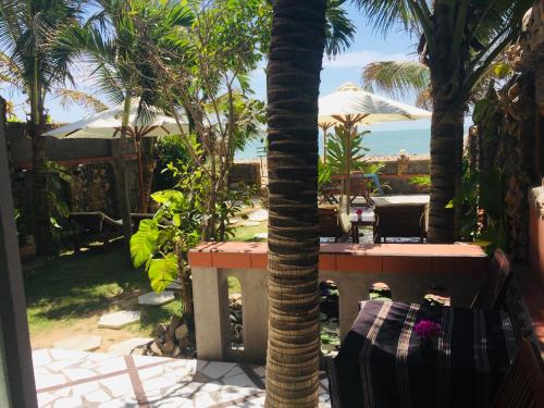 a palm tree with a table and a view of the ocean at Sầm Sơn Boutique Hotel Phan Thiết in Phan Thiet