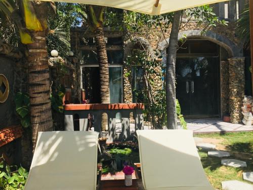 two chairs in front of a house at Sầm Sơn Boutique Hotel Phan Thiết in Phan Thiet