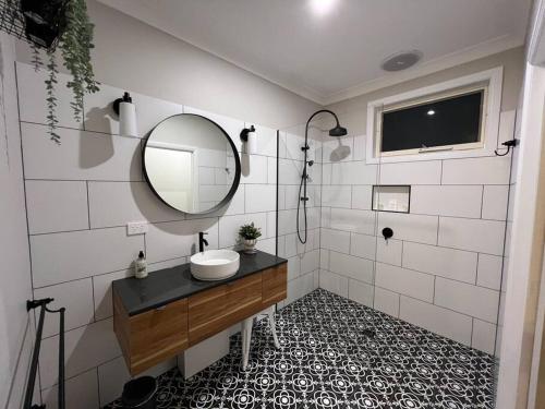 a bathroom with a sink and a mirror at Cosy Country Cottage in Neerim South