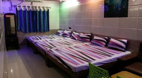 a large bed with purple pillows in a room at Sri Priya Lodge in Dharmapuri