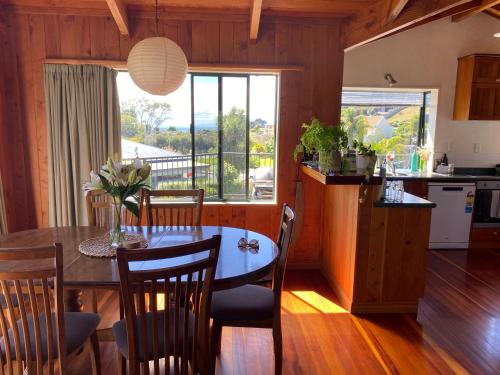 a kitchen and dining room with a table with chairs and a window at Unit 12 Kaiteri Apartments and Holiday Homes in Kaiteriteri