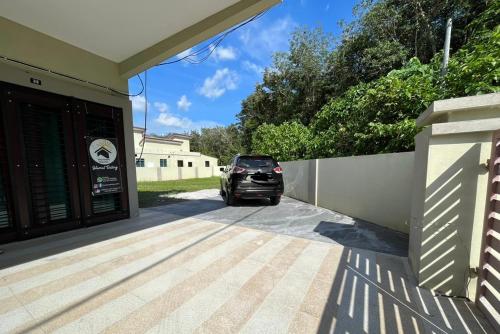 a car parked in the driveway of a house at Homestay Bota Sunrise in Kampung Bota Kiri