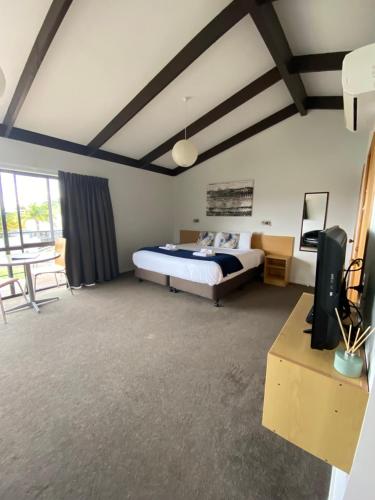 um quarto com uma cama e uma televisão num quarto em Unit 4 Kaiteri Apartments and Holiday Homes em Kaiteriteri