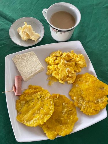 a plate of eggs and cheese and a cup of coffee at Hotel Palma Azul Beach in Coveñas