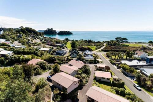 an aerial view of a village with the ocean in the background at Unit 6 Kaiteri Apartments and Holiday Homes in Kaiteriteri