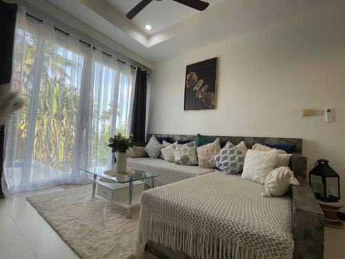 Villa Sumalee Sea' View في كوه ساموي: غرفة معيشة مع أريكة وطاولة زجاجية