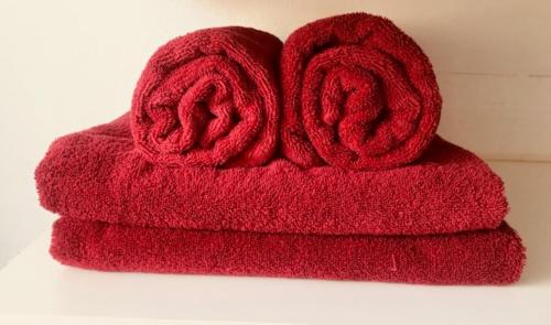 een stapel rode handdoeken met een roos erop bij Tamworth Budget Motel in Tamworth