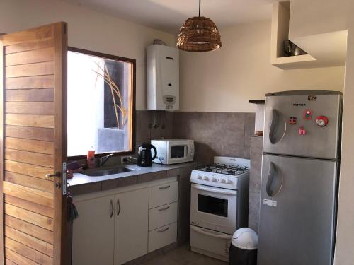 Una cocina con refrigerador, estufa y fregadero. en Las Lavandas Purmamarca, en Purmamarca