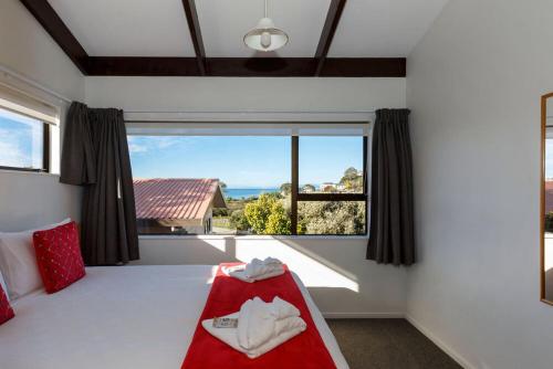 a bedroom with a bed with a large window at Unit 8 Kaiteri Apartments and Holiday Homes in Kaiteriteri