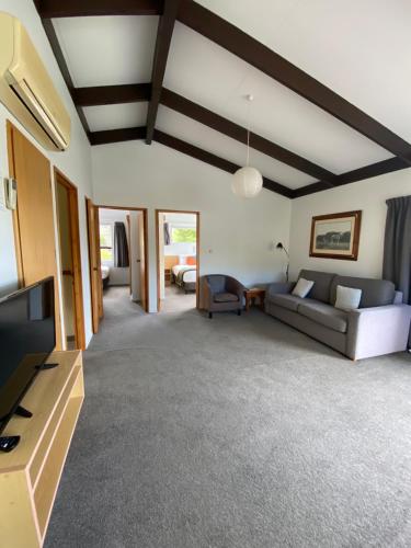 a living room with a couch and a tv at Unit 8 Kaiteri Apartments and Holiday Homes in Kaiteriteri