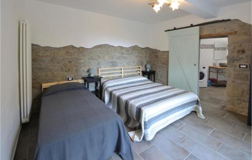 a bedroom with a bed and a stone wall at Awesome Home In Burzanella With Wifi And 4 Bedrooms 