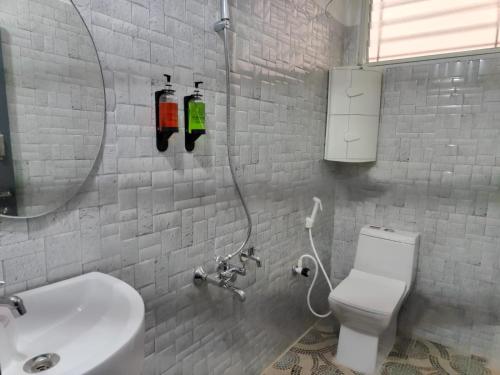 a bathroom with a sink and a toilet and a mirror at Navilu Homes in Mysore