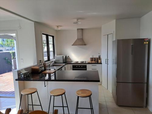a kitchen with a stainless steel refrigerator and stools at Richmond Central 3bdrm House sleeps 7 in Richmond