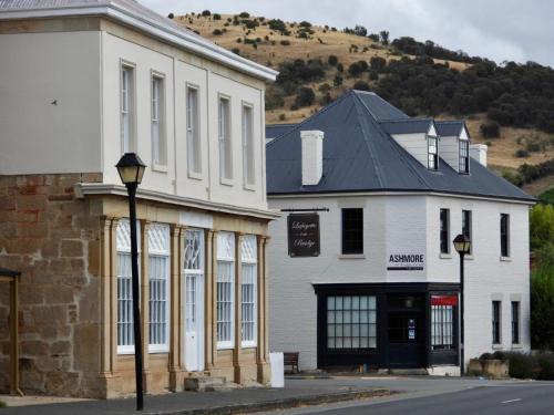 a white building with a black roof next to a street at Aquila Eco Retreat in Richmond