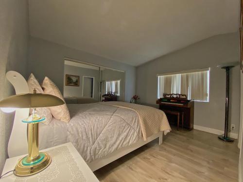 ein Schlafzimmer mit einem Bett und einem Tisch mit einer Lampe in der Unterkunft Sun Angel House #1 Pahrump in Pahrump