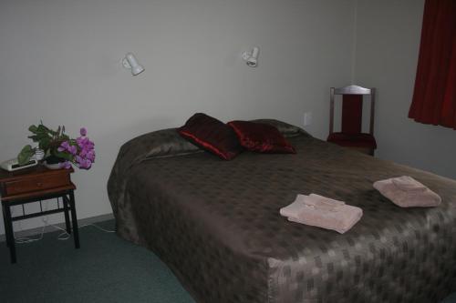a bedroom with a bed with two towels on it at Westport Kiwi Holiday Park & Motels in Westport