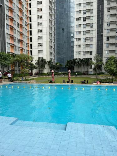Fully furnished 1 BR Condo unit في مانيلا: مسبح ازرق كبير مع مباني في الخلف