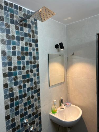 a bathroom with a sink and a mirror at Teakwood Suite - Nokha House in Kolkata
