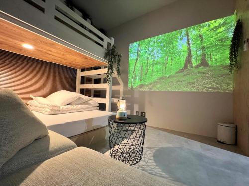 a bedroom with two beds and a large screen at 365BASE outdoor hostel in Hamamatsu
