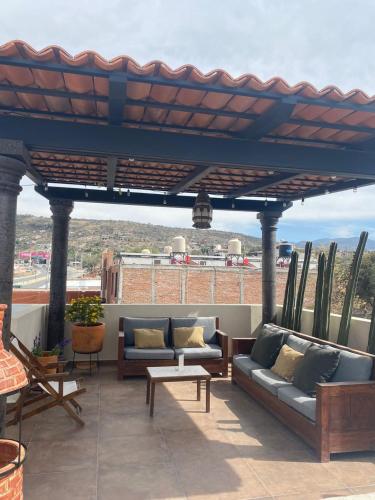a patio with couches and tables on a roof at Hotel La Lejona in San Miguel de Allende