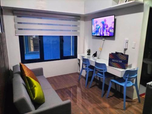 a living room with a couch and a table and a tv at Air Residences Staycation in Manila