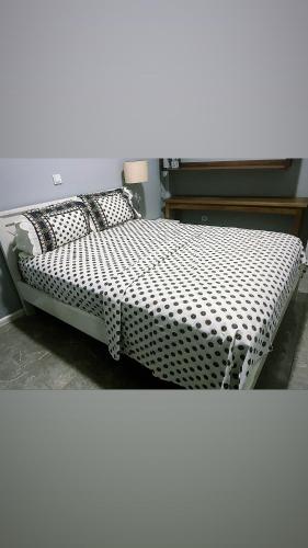 Bett mit schwarzweißer Bettwäsche und Kissen in der Unterkunft The Gulch in Douala