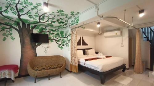 1 dormitorio con 1 cama y un mural de árboles en Vlodge House, en Chiang Mai